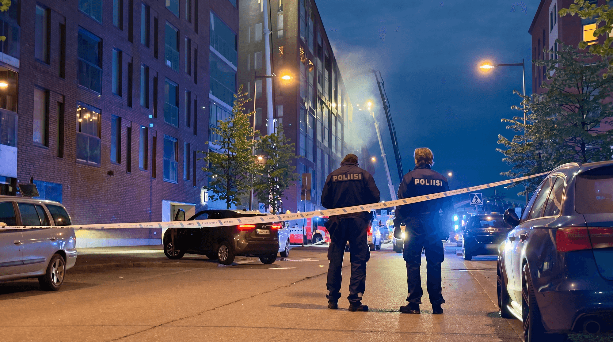 Blue emergency lights illuminating the street at the Leonkatu fire scene