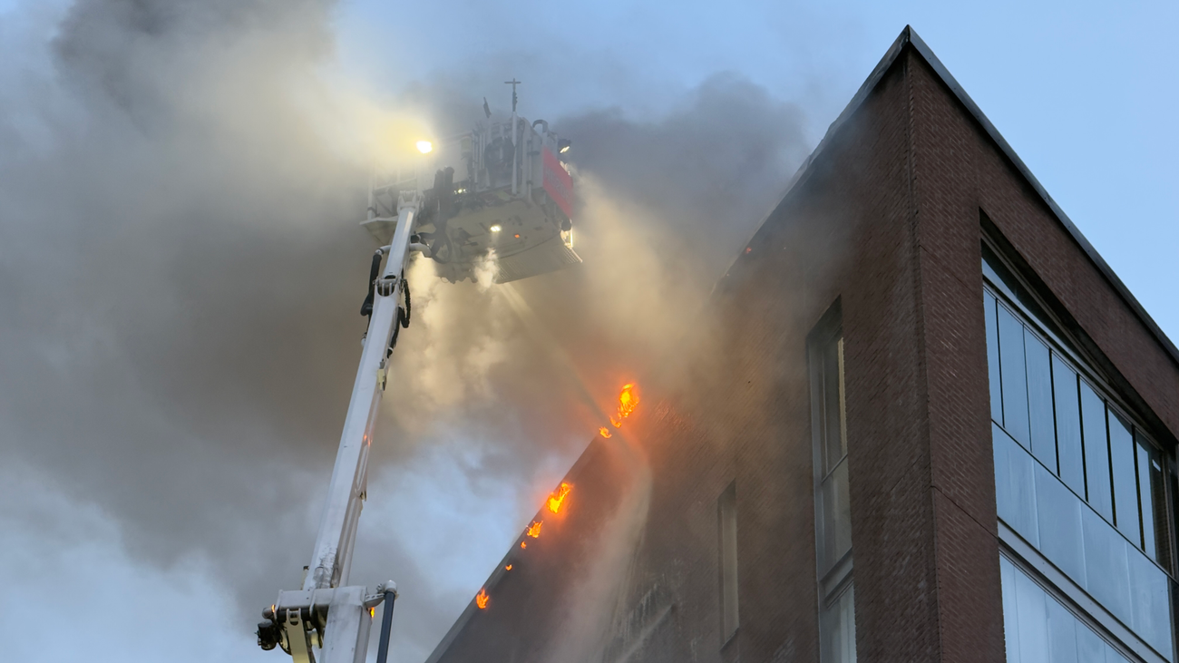 Firefighters working from a ladder truck at the Leonkatu fire scene